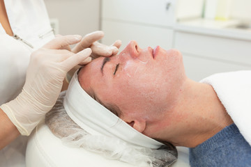 Obraz na płótnie Canvas Face beauty treatment. Close-up of woman getting facial laser polishing and rejuvenation face procedure, cosmetologist using hardware apparatus