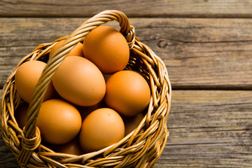 basket of eggs on old wooden background