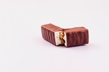 Chocolate candy with nougat and walnuts on a white background