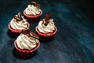 beautiful Cupcakes with cream and cookies on a black background