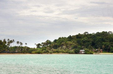 Amber sand beach, rocks, coconut palm trees and turquoise tropical sea on Koh Chang Island in Thailand