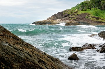 Deserted rocky coastline and turquoise tropical storm sea with a surf on tropical Koh Chang island in Thailand