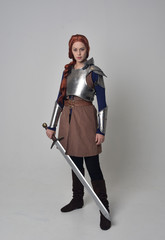 full length portrait of a  red haired girl wearing medieval warrior costume and steel armour,...