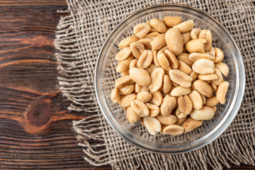 Salt peanut on dark wooden background.
