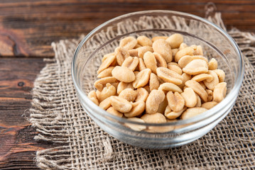 Salt peanut on dark wooden background.