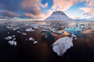 Iceland snaefellsnes peninsula and famous Kirkjufell. Kirkjufell is a beautifully shaped and a symmetric, free standing mountain in Iceland. Frozen view of Kirkjufell (church mountain).