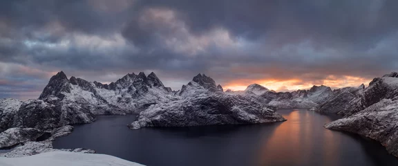 Fototapete Städte & Reisen Winter dramatic landscape with snowy mountains, sea, blue and orange cloudy sky reflected in water at sunset. Beautiful Lofoten islands, Norway. Norwegian fjords background. Christmas time concept  © Michal