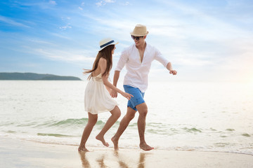 Romantic couple relaxing on the beach and enjoying beautiful sea view