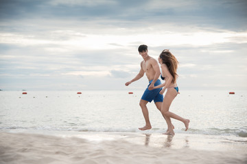 Fototapeta premium Loving couple enjoying walking on the beach