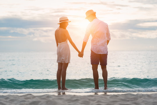 Loving couple enjoying walking on the beach enjoying the sunset,summer vacation