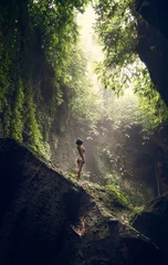 Wandaufkleber Waterfall Tukad Cepung. Waterfall in Bali. The gorge. A girl in a bathing suit at the waterfall Travel. © maksymbondarenko