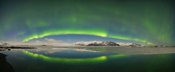 Fototapeta na wymiar Beautiful panoramic Aurora Borealis or The Northern Lights for background view in Iceland, Jokulsarlon during winter season. Sky with stars and green polar lights. Night landscape with aurora. Concept