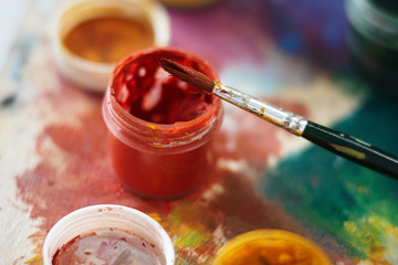 A jar of red gouache and a brush, which was used for drawing, are on the palette, painted in...