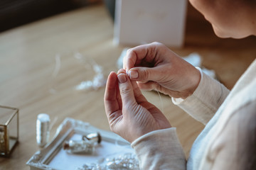 Closeup macro photo of details, workplace of decorator and creator of wedding imitation jewelry. Woman's hands in a process of creation