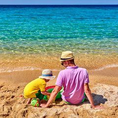 Toddler boy on beach with father