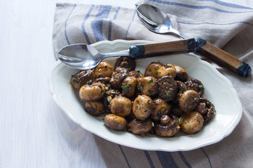 Karamelisierte Champignons mit Aceto, Knoblauch, Kräutern auf einer Servierplatte