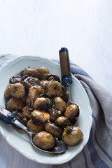 Karamelisierte Champignons mit Aceto, Knoblauch, Kräutern auf einer Servierplatte