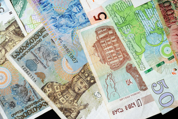 Different countries money background close up. Belarusian rubles, Georgian lari, Polish zloty, Israeli shekels, Vietnamese dongs