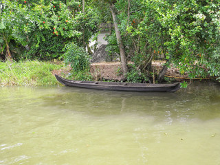 Boat near the shore on the background of green trees in Kerala Kochi