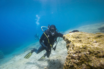 Naklejka na ściany i meble Scuba diver posing underwater