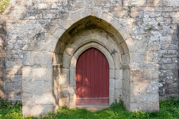 French landscape - Bretagne. Front door of an old church lost in the forest.