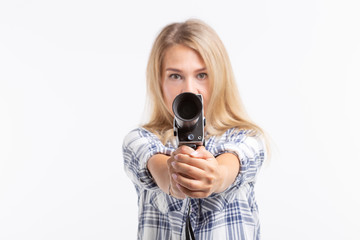 Joke, photographing and humor concept - blonde young woman with retro camera like a gun over white...