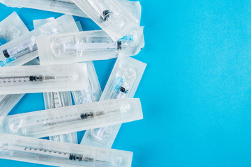 Large packages with cocaine on a blue background, medical syringe close