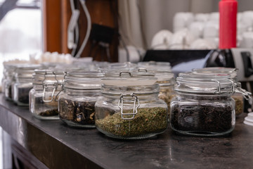 Sealed glass jars of different types of tea at the restaurant bar