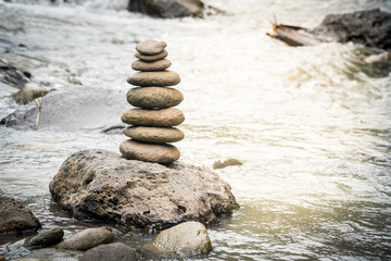 Fototapeta na wymiar Balancing stones on river rocks