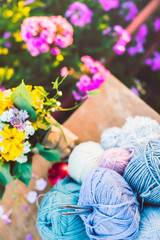 Womens hobby. Skeins of yarn and knitting needles in the basket on wooden background.	