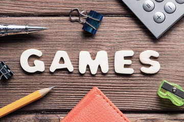 Game word on wooden table and office stationary around