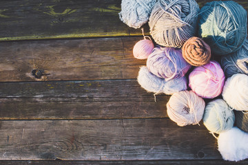 Women's hobby. Colorful skeins of yarn on wooden old background.