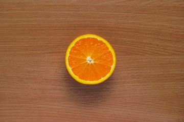 Orange, half of orange, orange lobule and basket with oranges on the wooden table