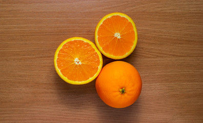 Orange, half of orange, orange lobule and basket with oranges on the wooden table