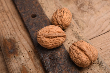 Walnut kernels and whole walnuts on rustic old oak table.