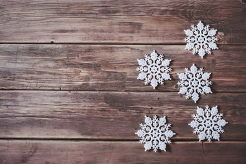 Obraz na płótnie Canvas Christmas decor. White snowflakes and garland with glowing lamps on wooden background.