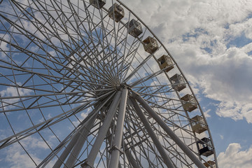 Ferris wheel on a background of blue sky and clouds