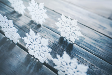 Christmas decor. White snowflakes on wooden background.	