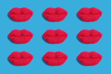 Knitted pink lips on a blue background.