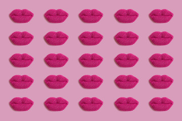 Knitted pink lips on a pink background.