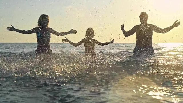 Happy family having fun on summer vacation. Father, mother and child playing in sea. Active healthy lifestyle concept