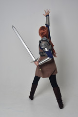 full length portrait of a  red haired girl wearing medieval warrior costume and steel armour,...