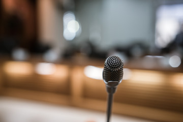 Front Microphone on abstract conference hall prepare for speaker on stage in seminar room, Business...