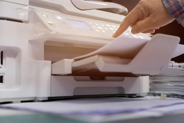 Business office Concept : Hand person employed press button on panel of printer for process...