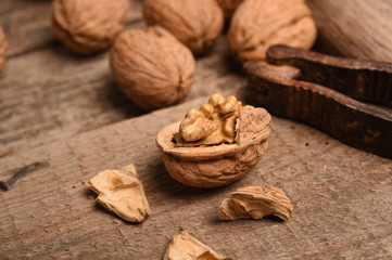Walnut kernels and whole walnuts on rustic old oak table.