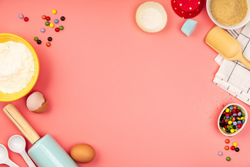 Baking or cooking ingredients on pink background, flat lay