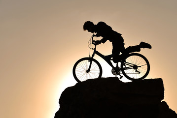 Fototapeta na wymiar silhouette of a cyclist on background of sunset