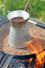 turkish coffee in cezve prepared on a pan with hot sand