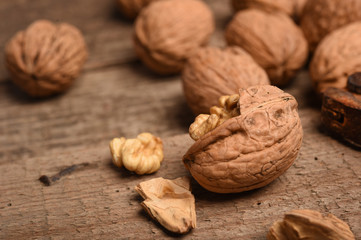 Walnut kernels and whole walnuts on rustic old oak table.