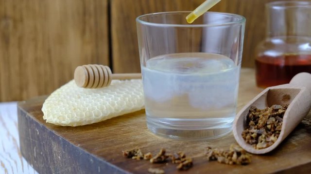 Treatment with propolis tincture. A bottle of propolis tincture and a wooden scoop of propolis granules. Medical preparations bee propolis. Apitherapy. Bee glue.